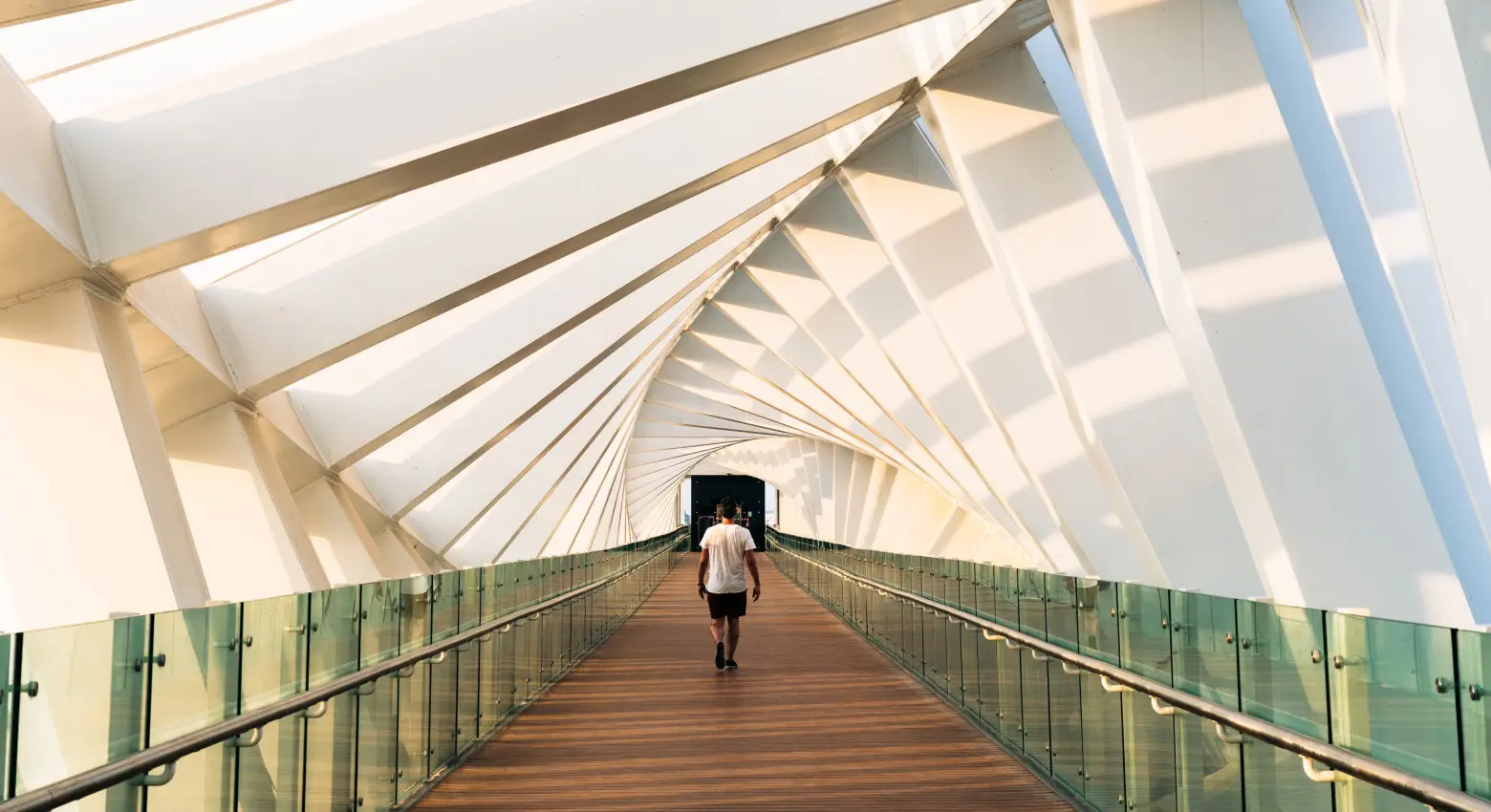 Persona che cammina su un ponte tra edifici moderni 