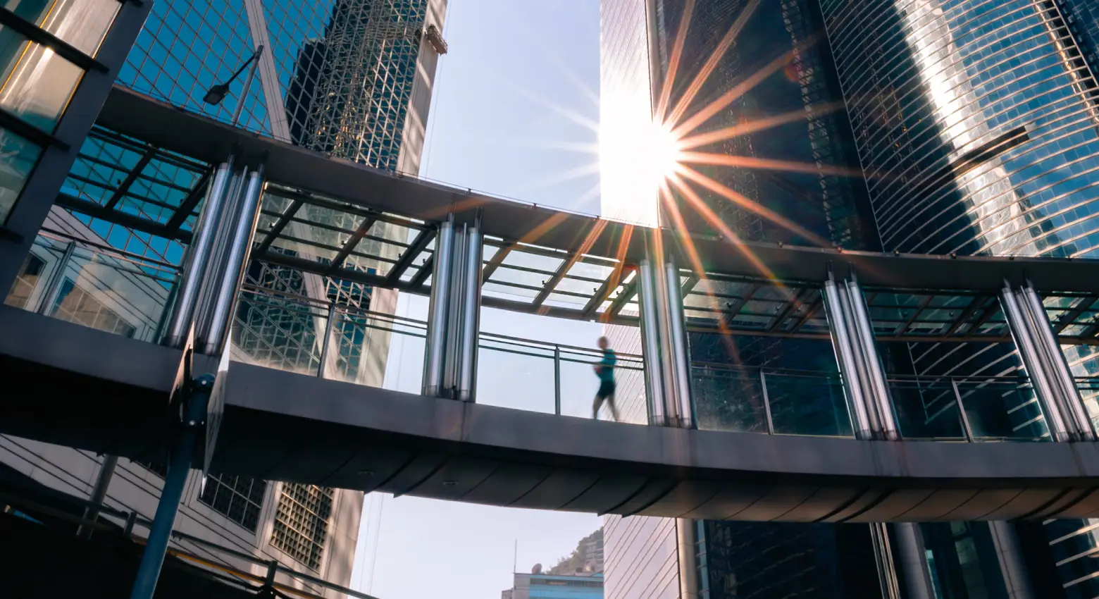 Persona che cammina su un ponte tra edifici moderni 