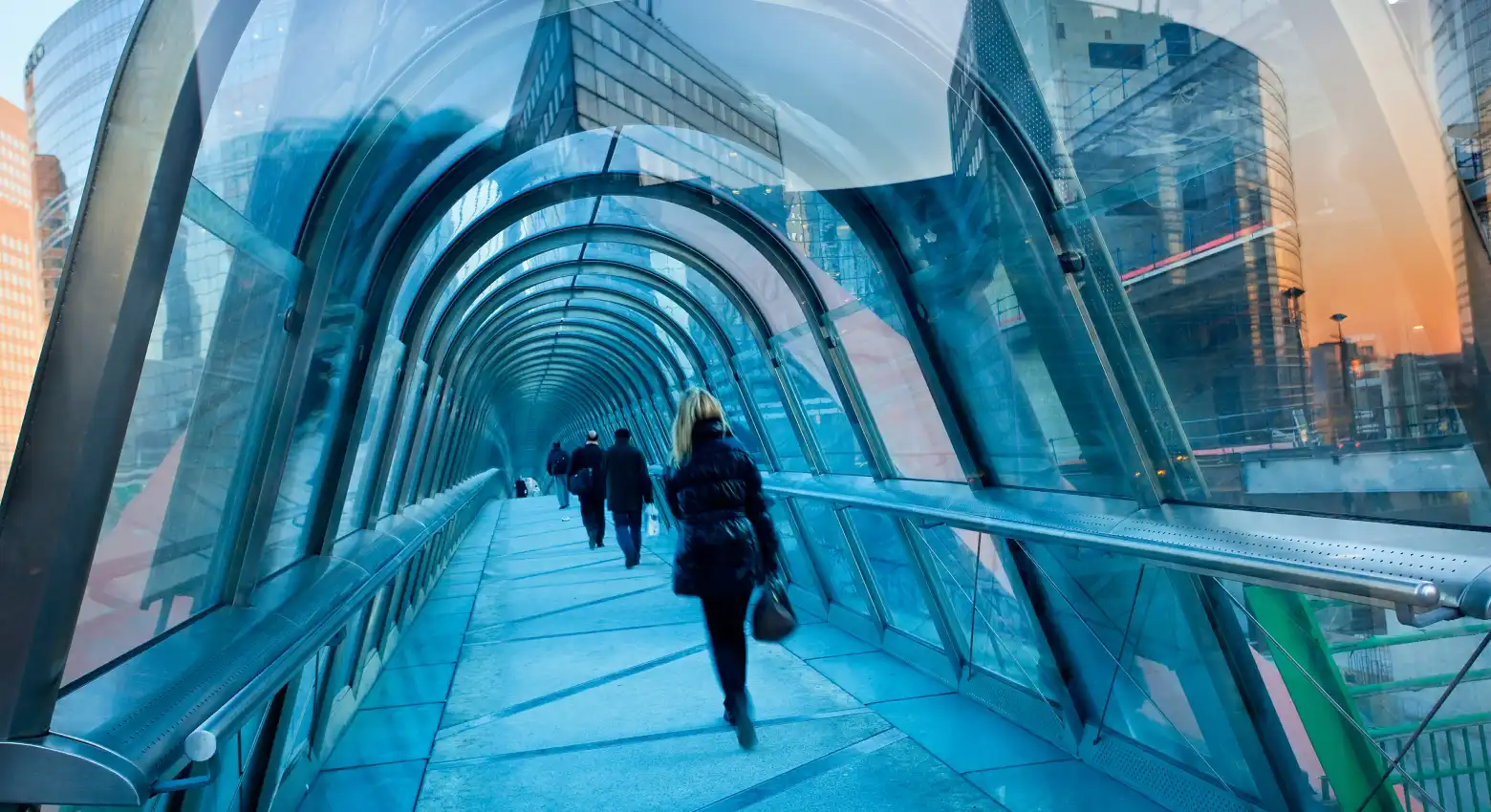 Persone che camminano su un ponte tra architetture moderne 