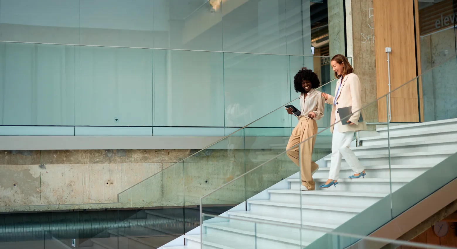 Due donne che camminano e parlano in un edificio moderno 