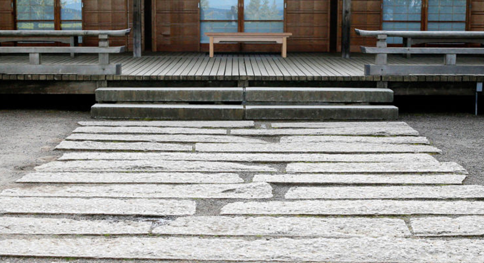 Sentiero acciottolato che conduce a un edificio e a una panchina 