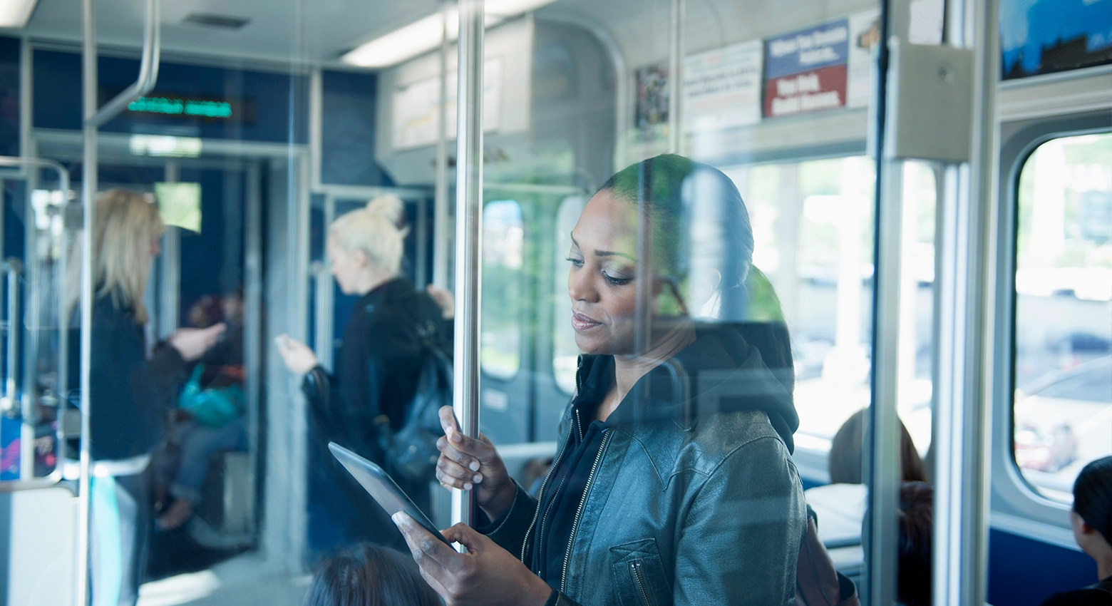 Una donna legge un tablet sul treno. 