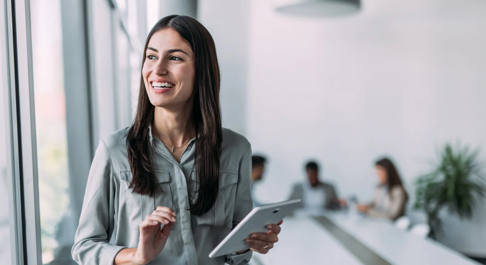 donna sorridente con tablet in ufficio