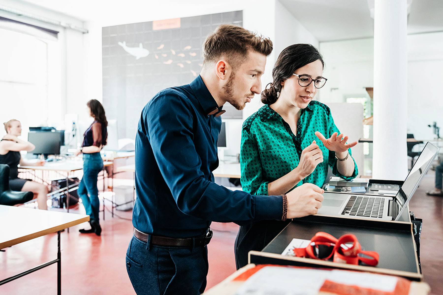 Un dipendente e una dipendente parlano di privacy mentre guardano un laptop.